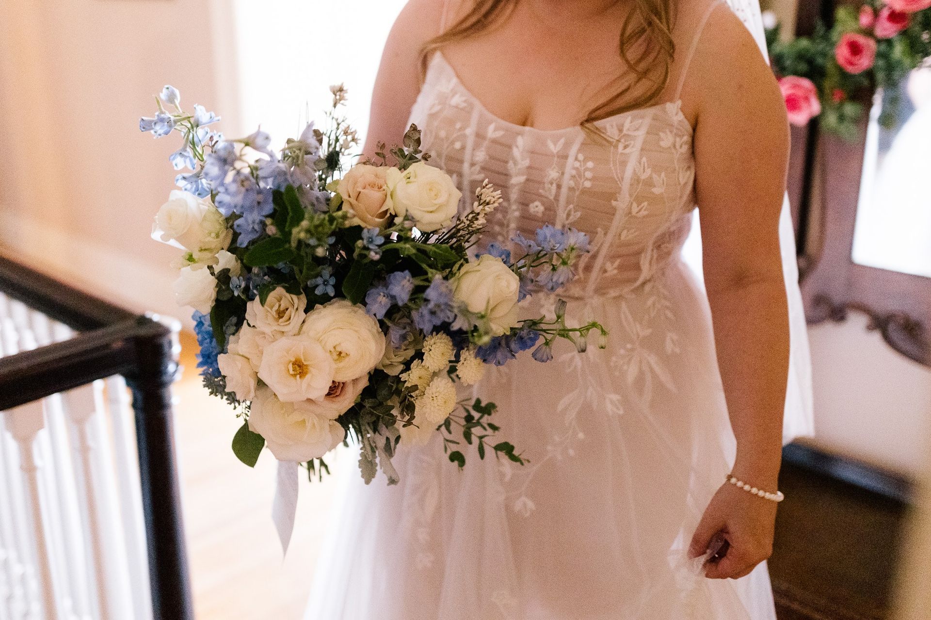 A bride in a wedding dress is holding a bouquet of flowers.