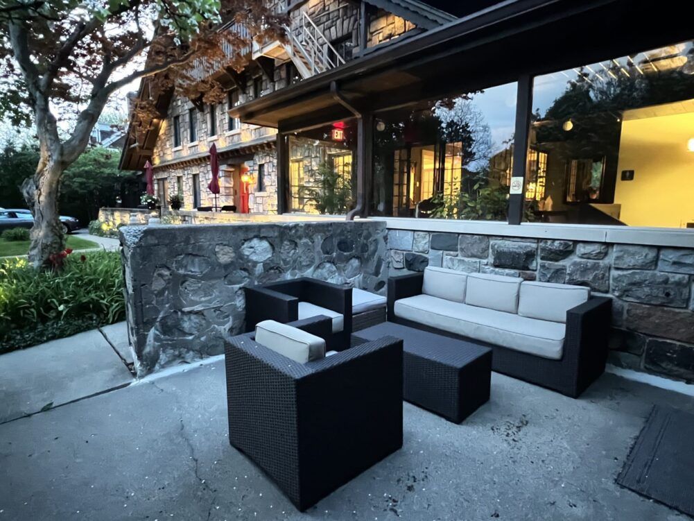 A patio with a couch and chairs in front of a building