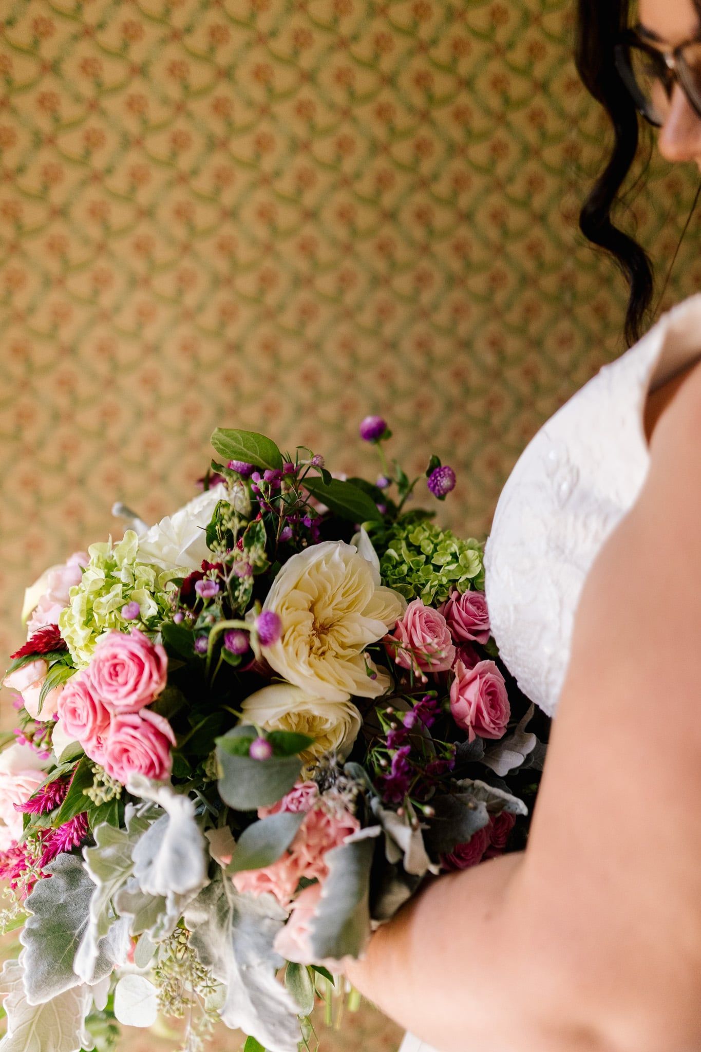 A woman in a white dress is holding a bouquet of flowers.