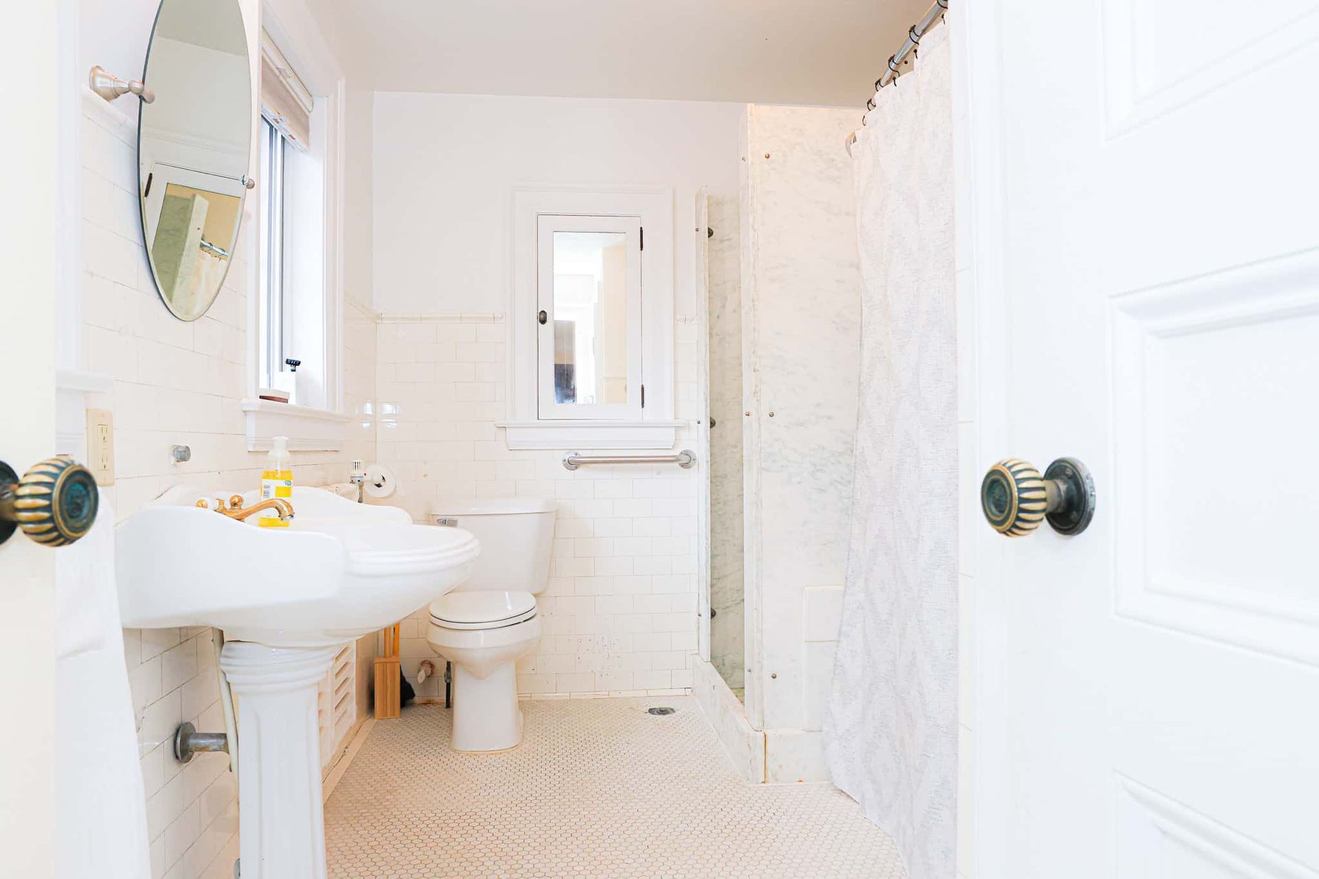 A bathroom with a sink , toilet , mirror and shower.