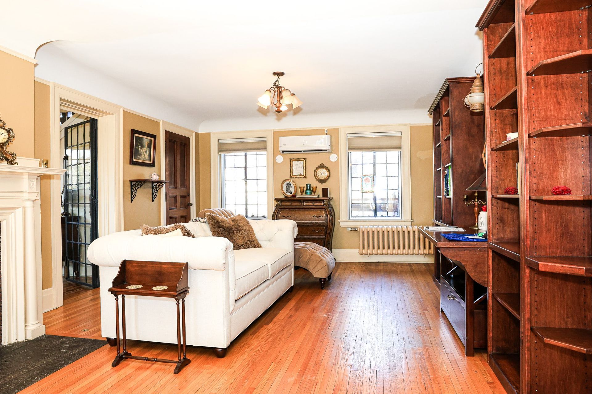 A living room with a white couch and wooden shelves