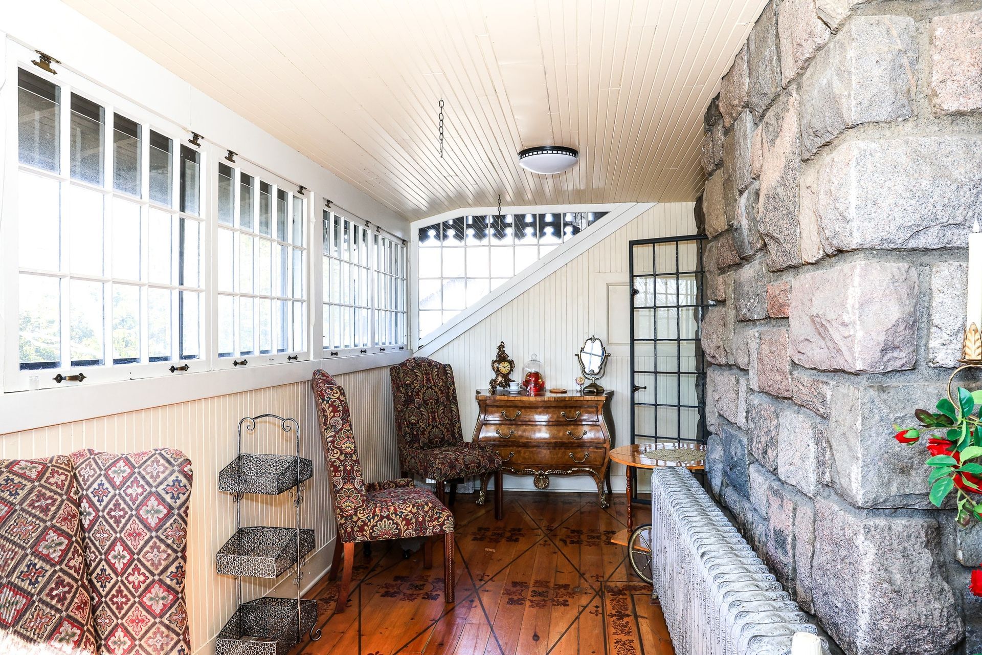 A living room with a lot of windows and a brick wall.