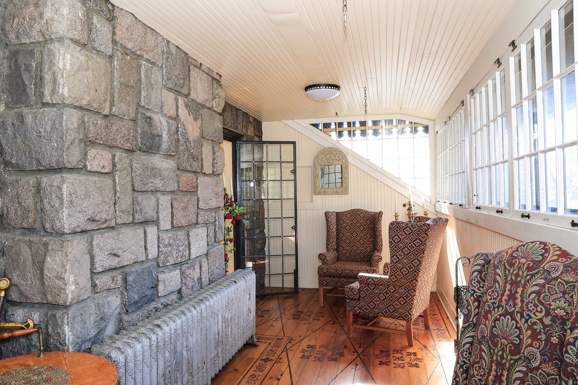 A living room with chairs and a stone wall