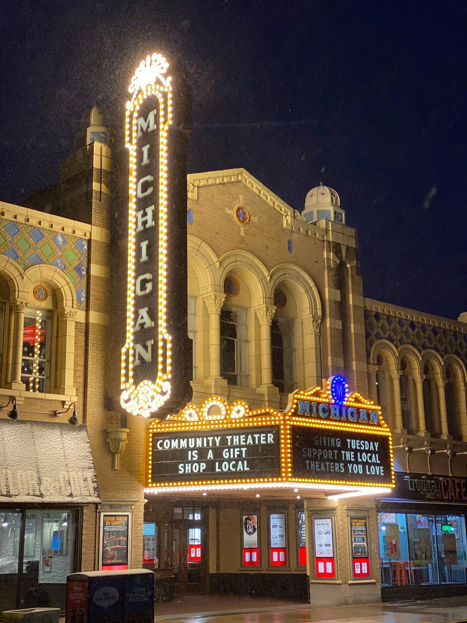 The michigan community theatre is lit up at night