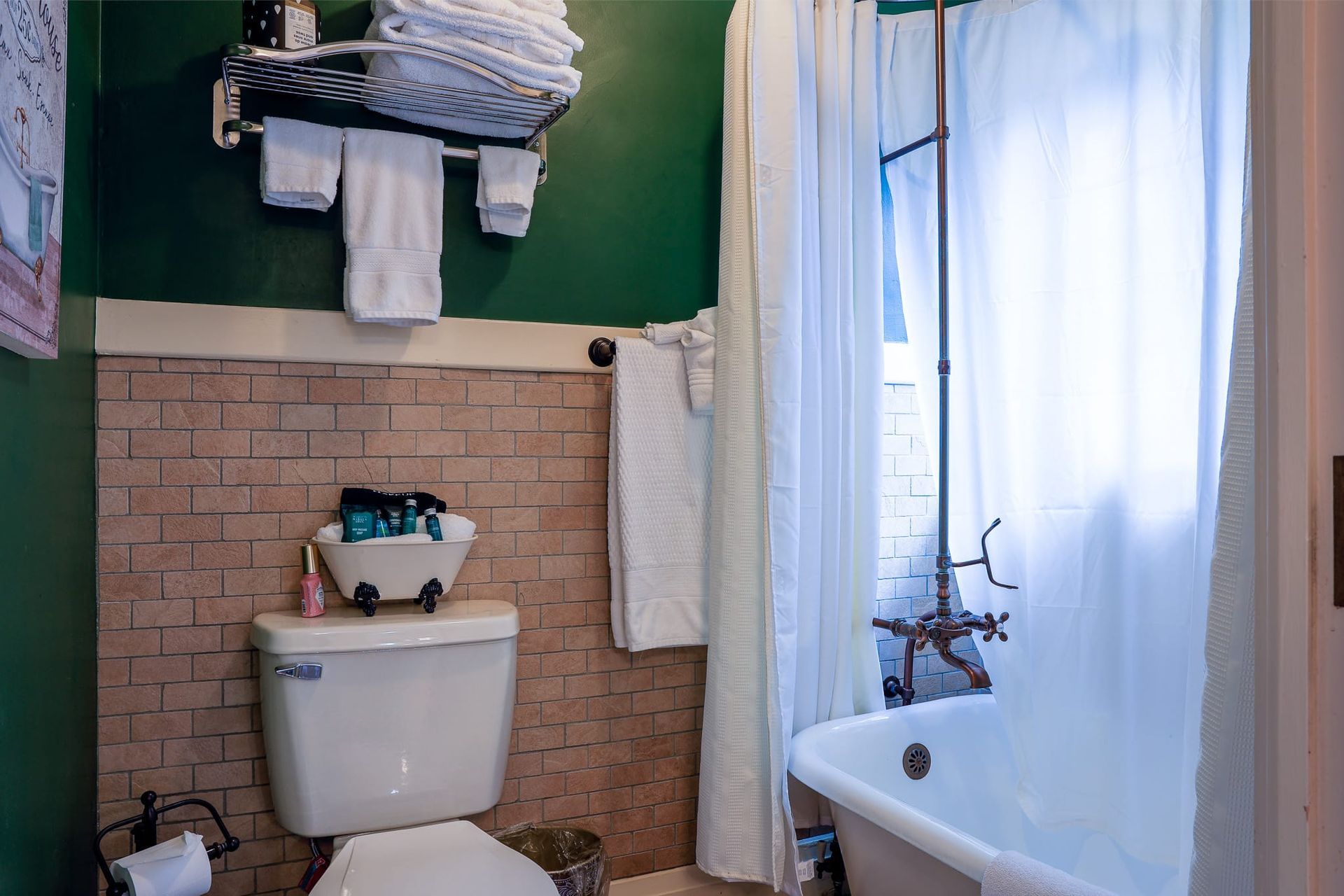 A bathroom with a toilet , tub , shower and green walls.