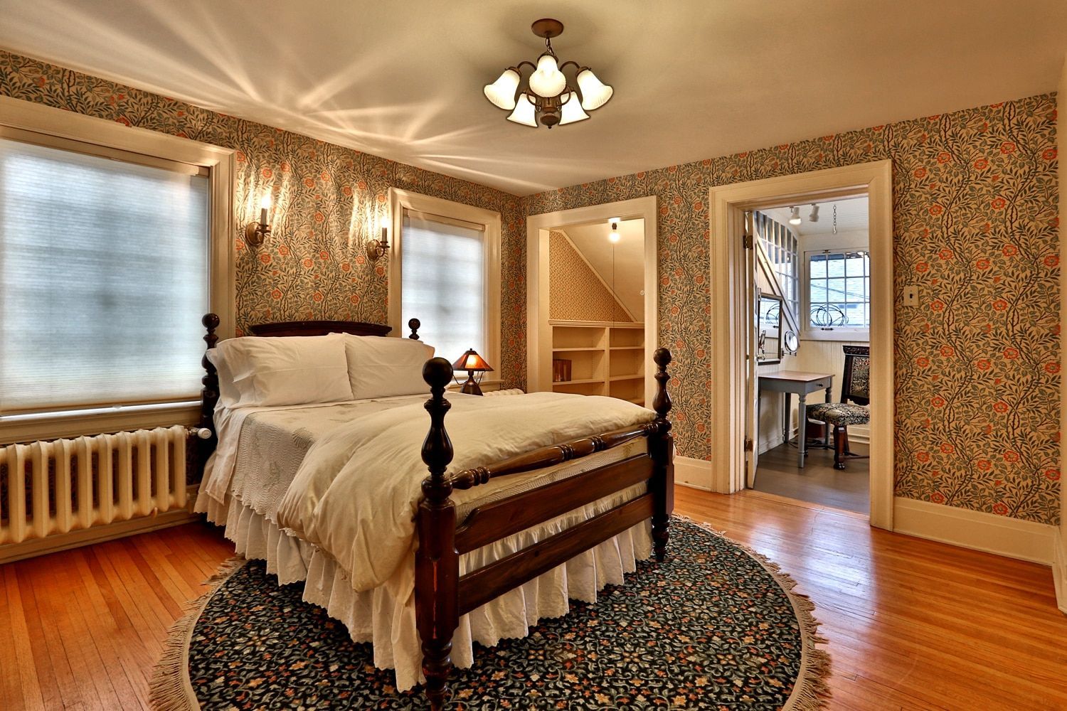 A bedroom with a bed and a rug on the floor