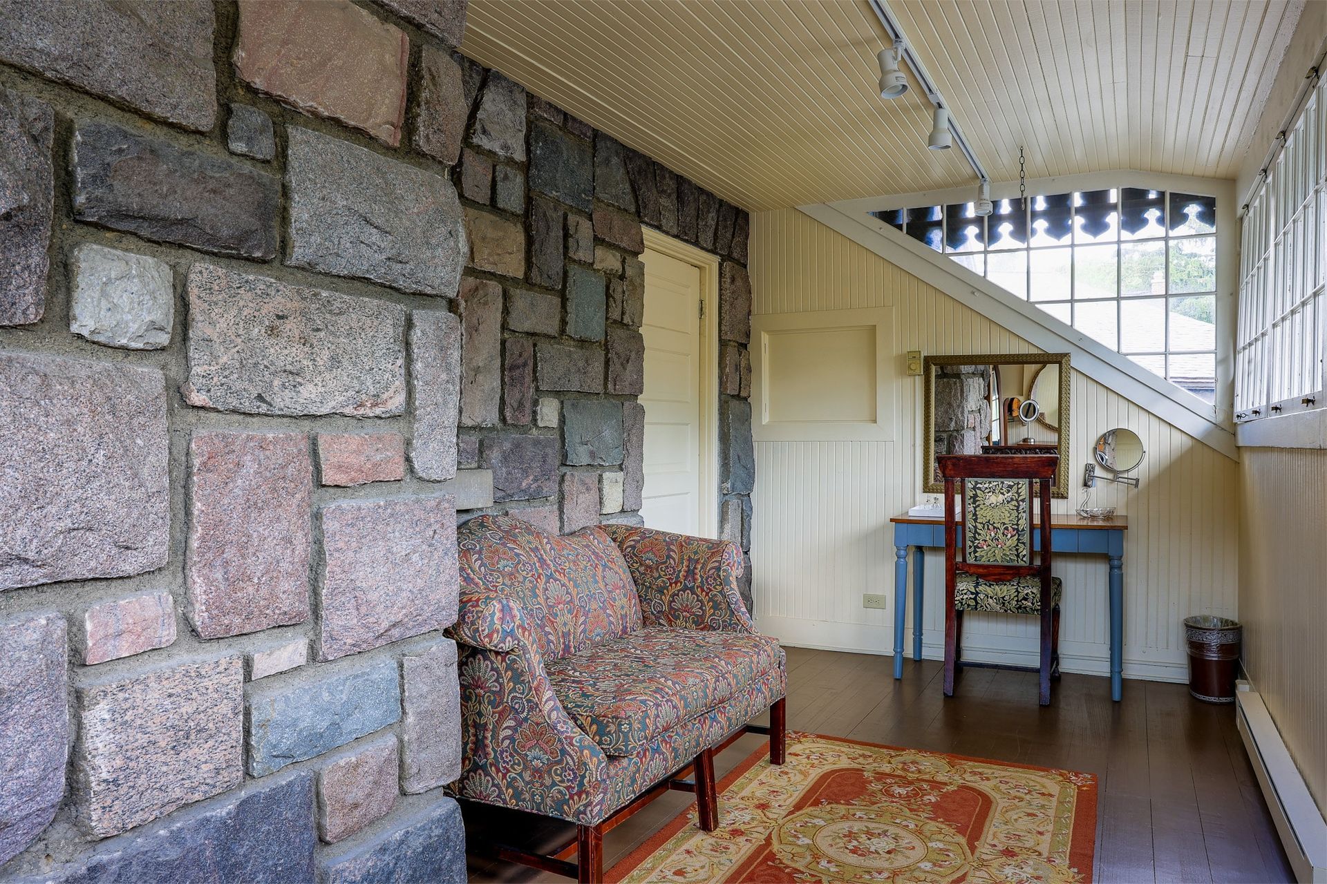 A living room with a stone wall and a couch