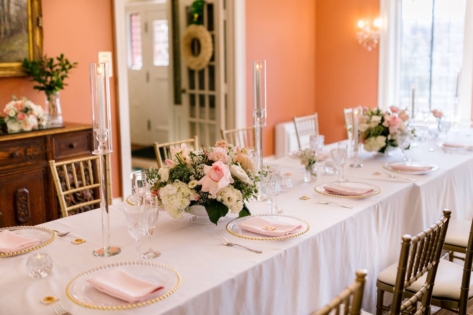 A long table with plates , candles , and flowers on it.