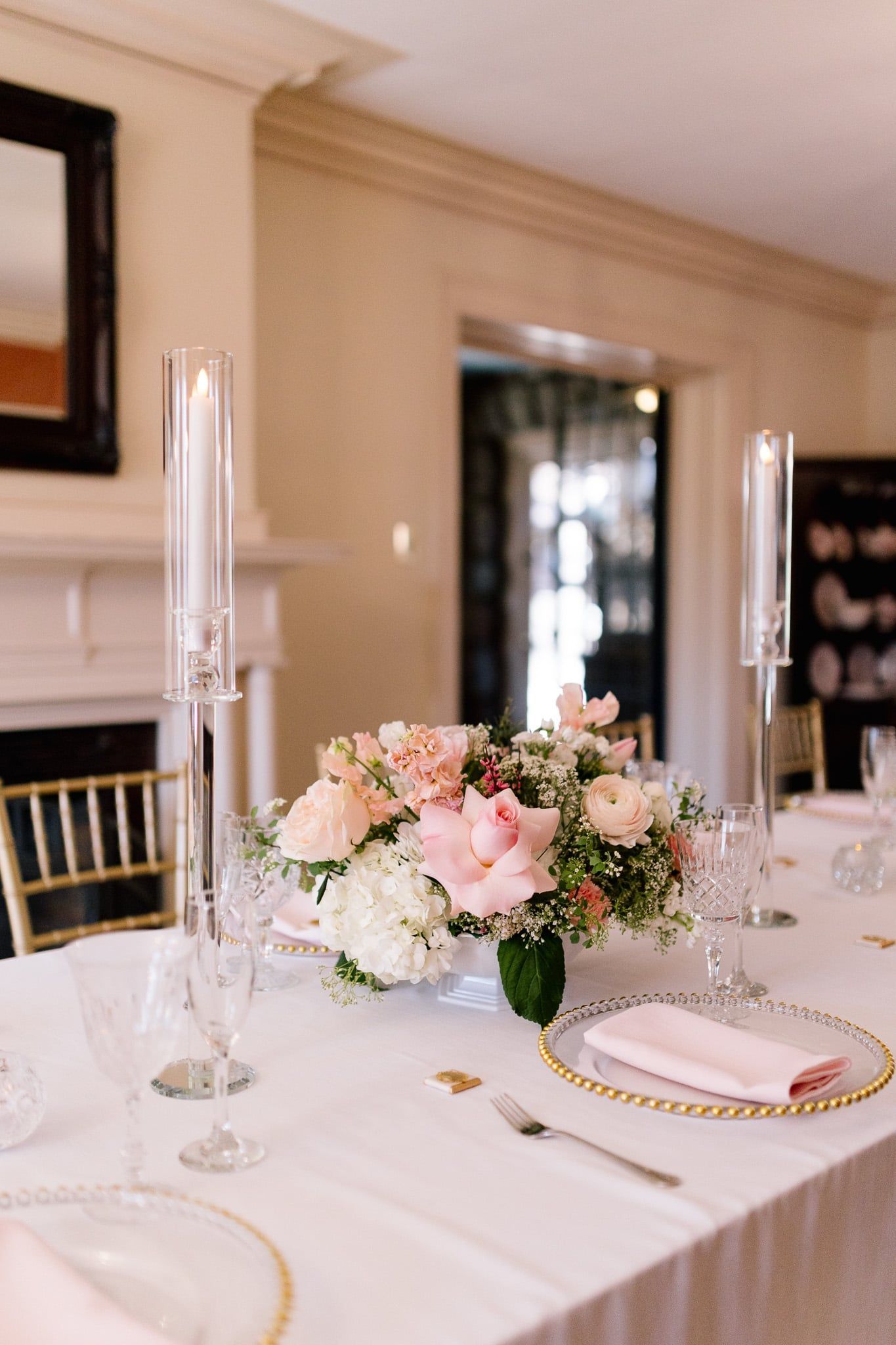 A table with a vase of flowers and candles on it.