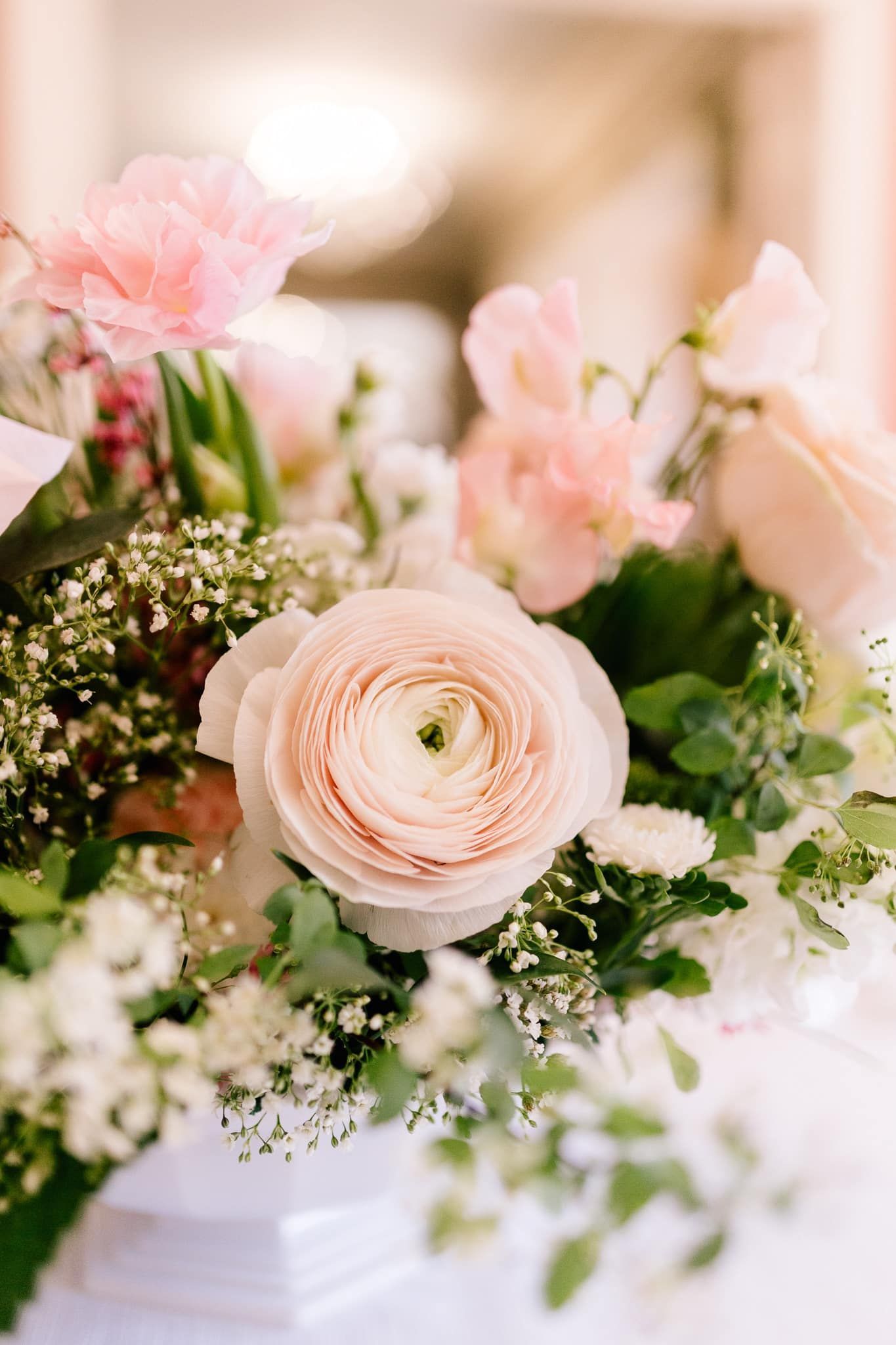 A close up of a bouquet of pink and white flowers on a table.