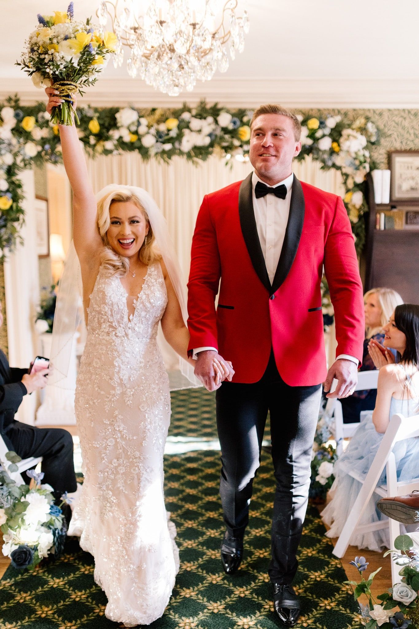 A bride and groom are walking down the aisle at their wedding holding hands.