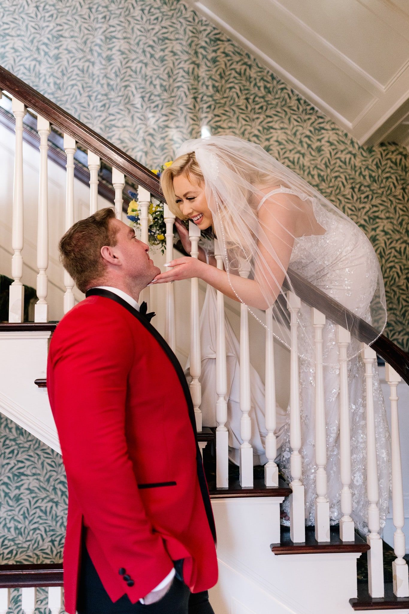 A bride and groom are posing for a picture on a set of stairs.