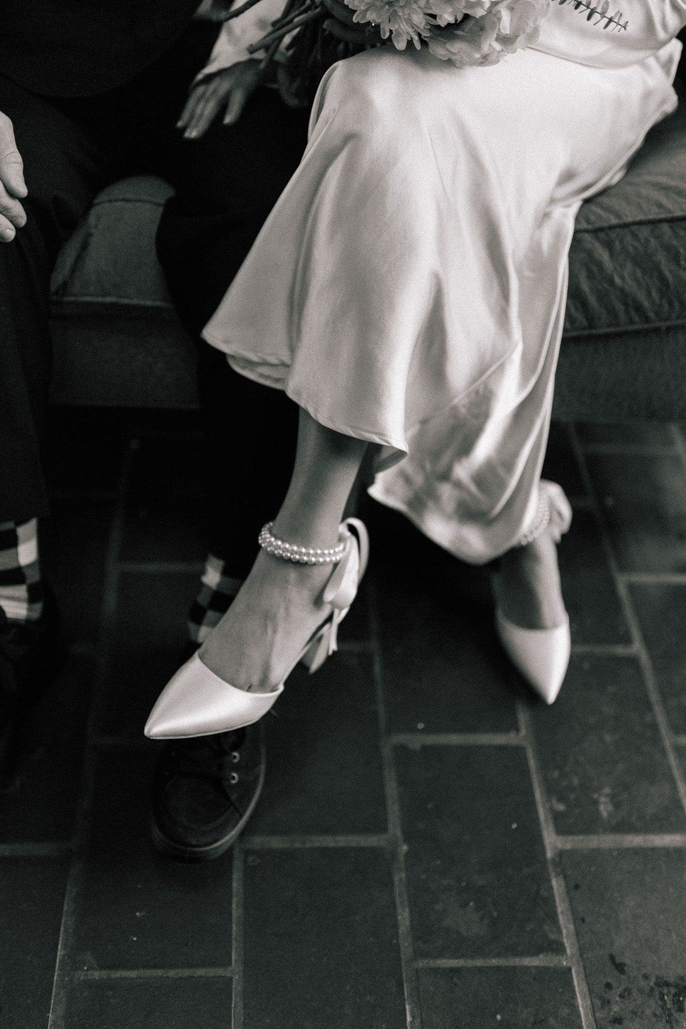 A black and white photo of a woman wearing white shoes