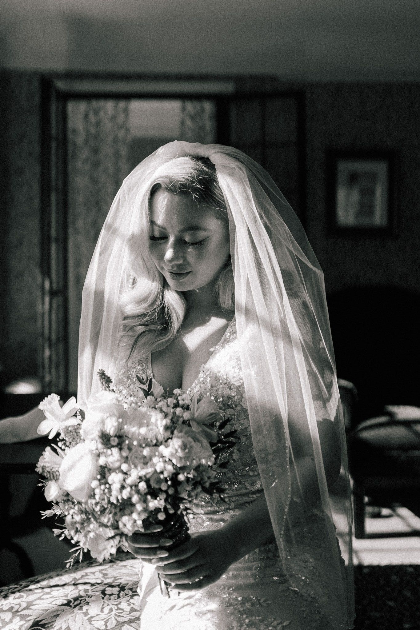 The bride is wearing a veil and holding a bouquet of flowers.