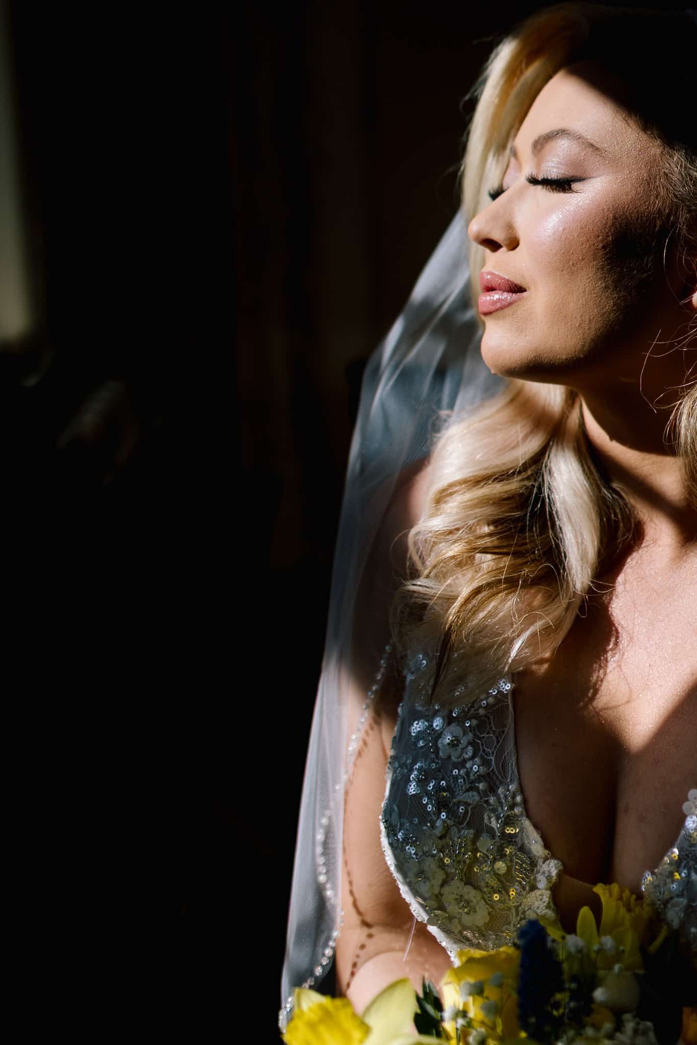 The bride is wearing a veil and holding a bouquet of flowers.