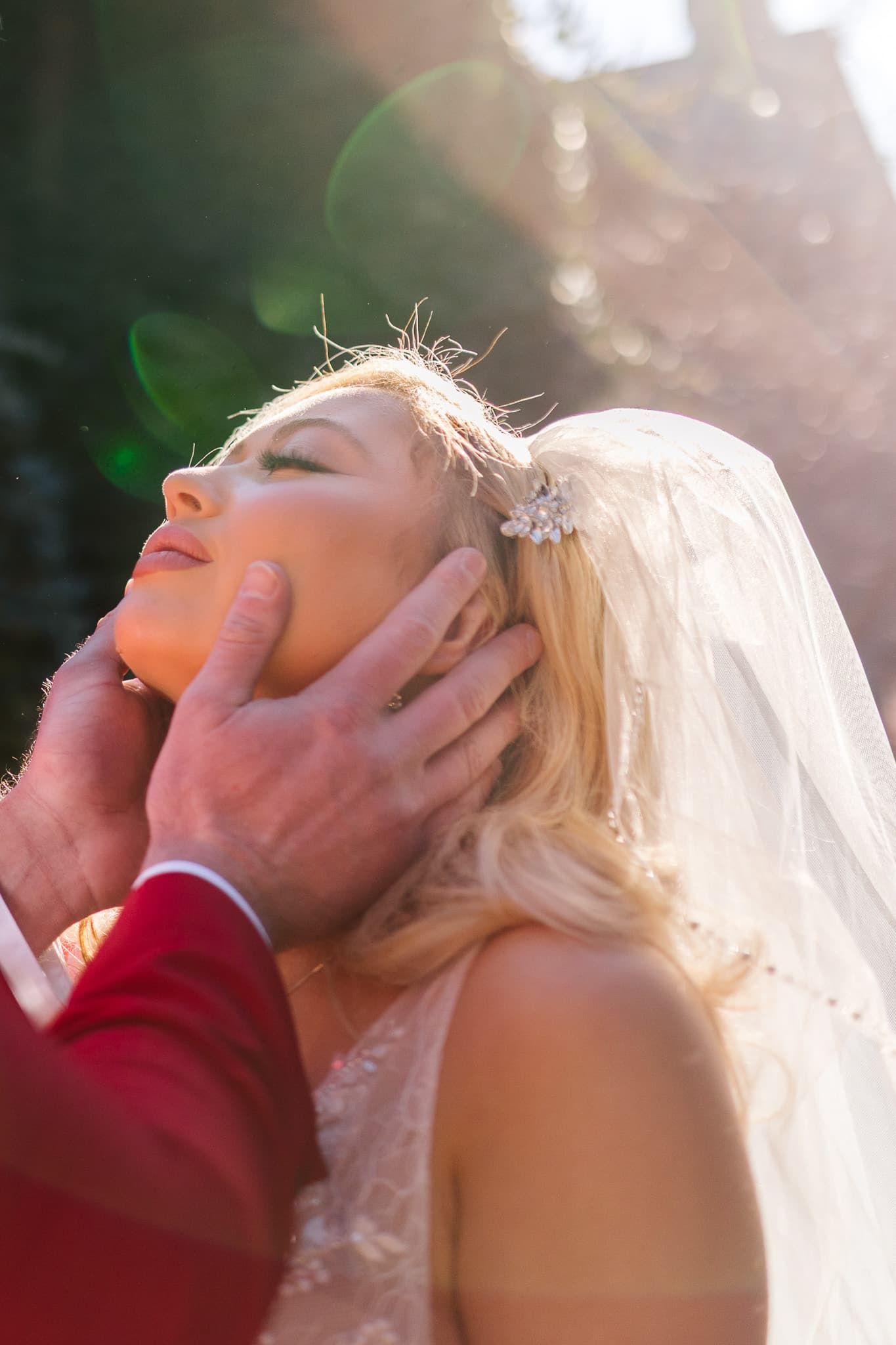 A man is touching the face of a woman in a wedding dress.