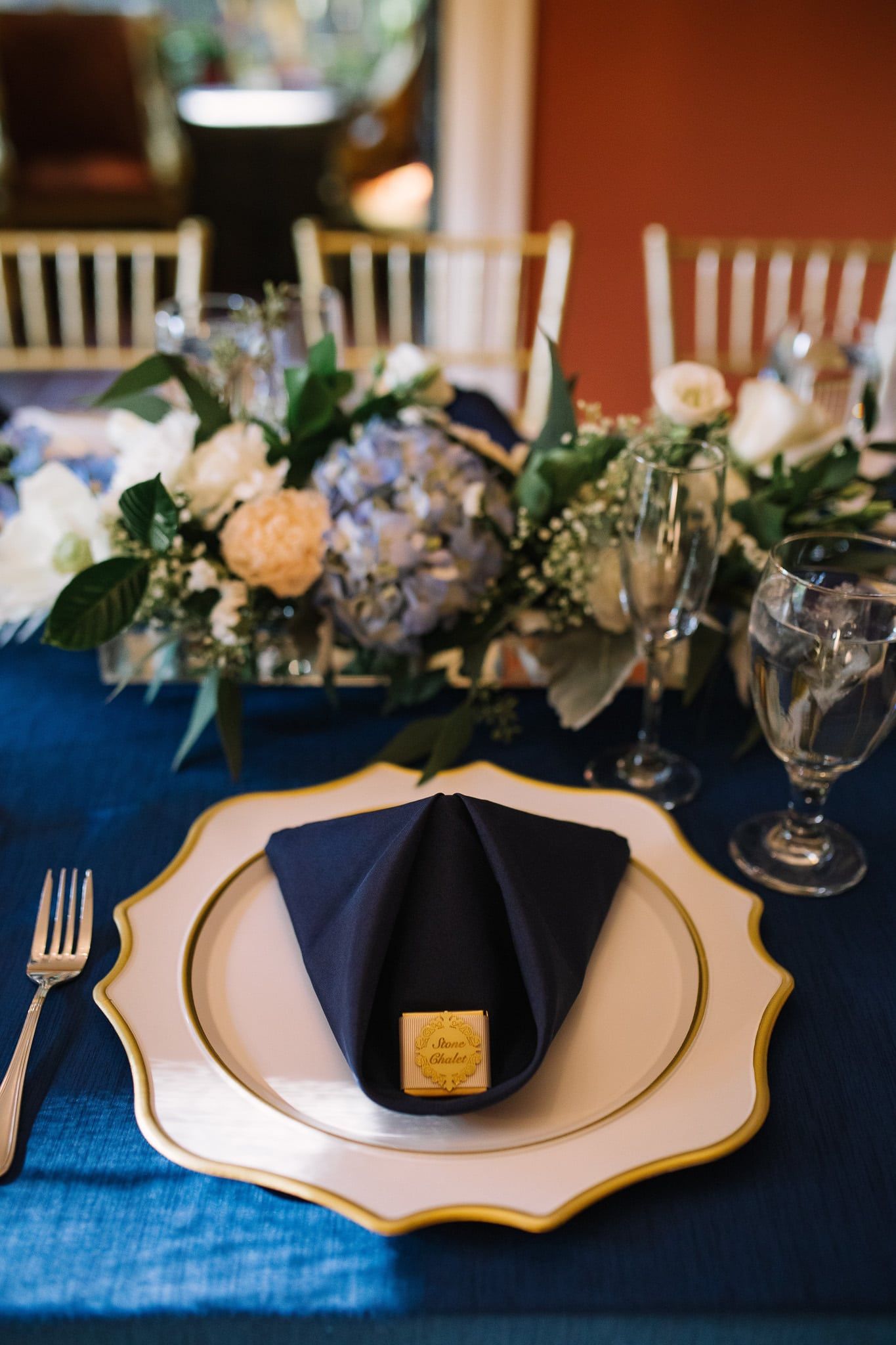 A table set for a wedding reception with plates , napkins , glasses , and flowers.