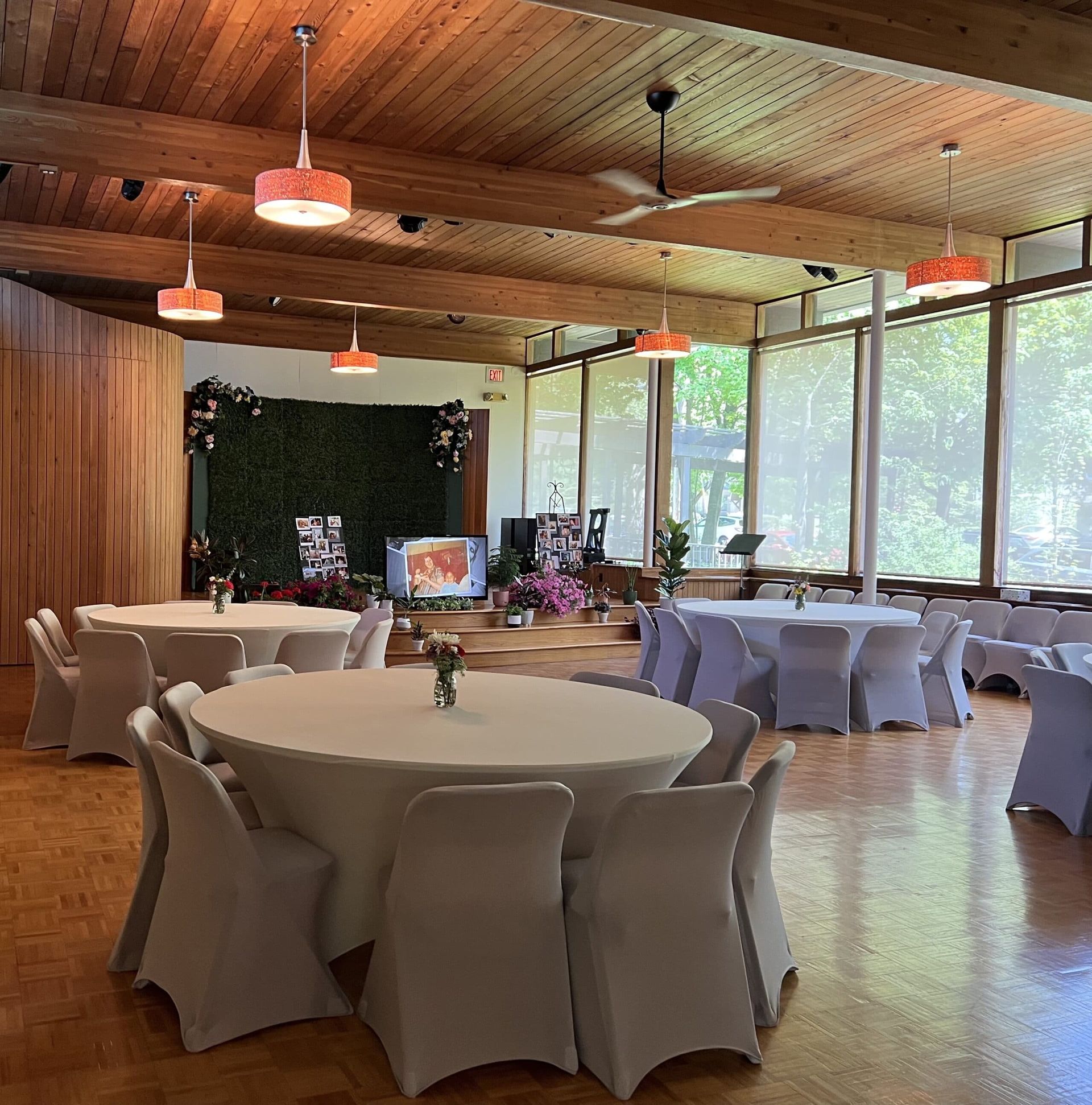 A large room with tables and chairs set up for a wedding reception.