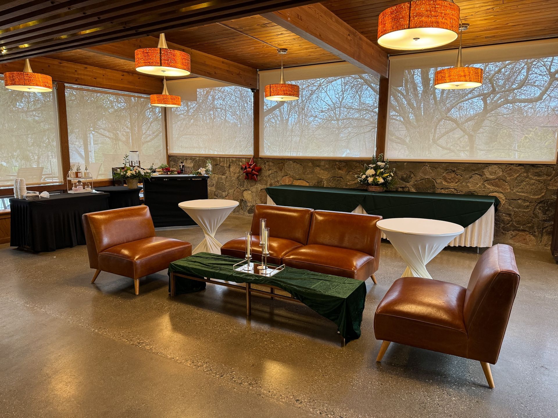 A large room with a couch , chairs , tables and lamps.