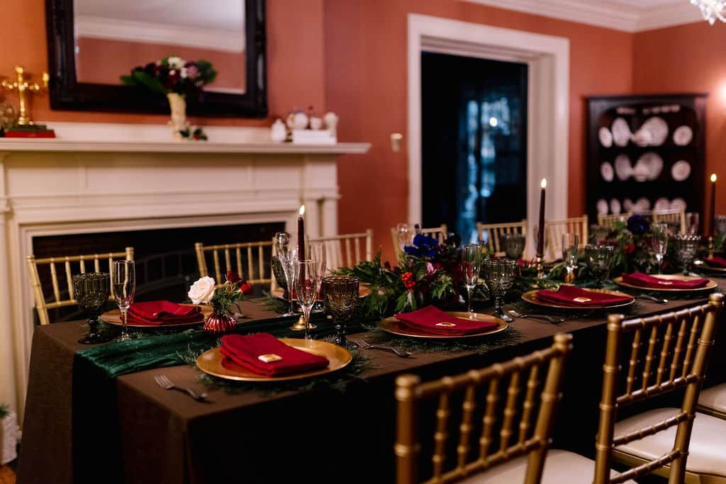 A dining room table with plates , glasses , and napkins on it.