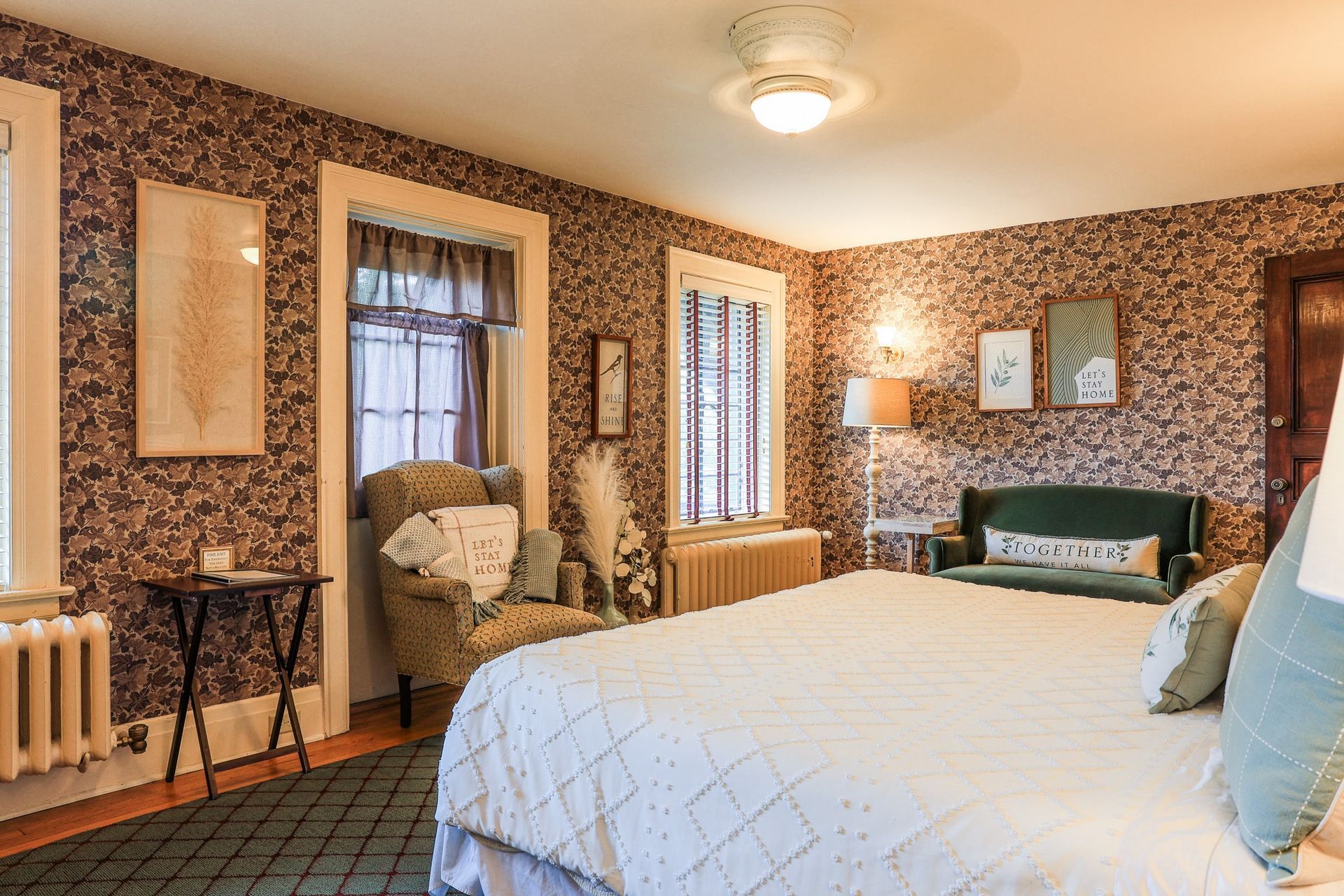 A bedroom with a king size bed , couch , chair and table.