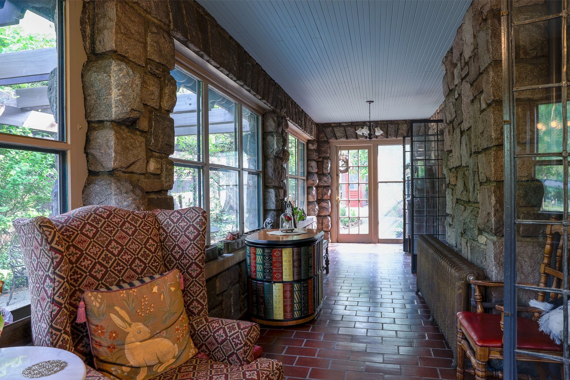 A long hallway with a chair and a table in a house.
