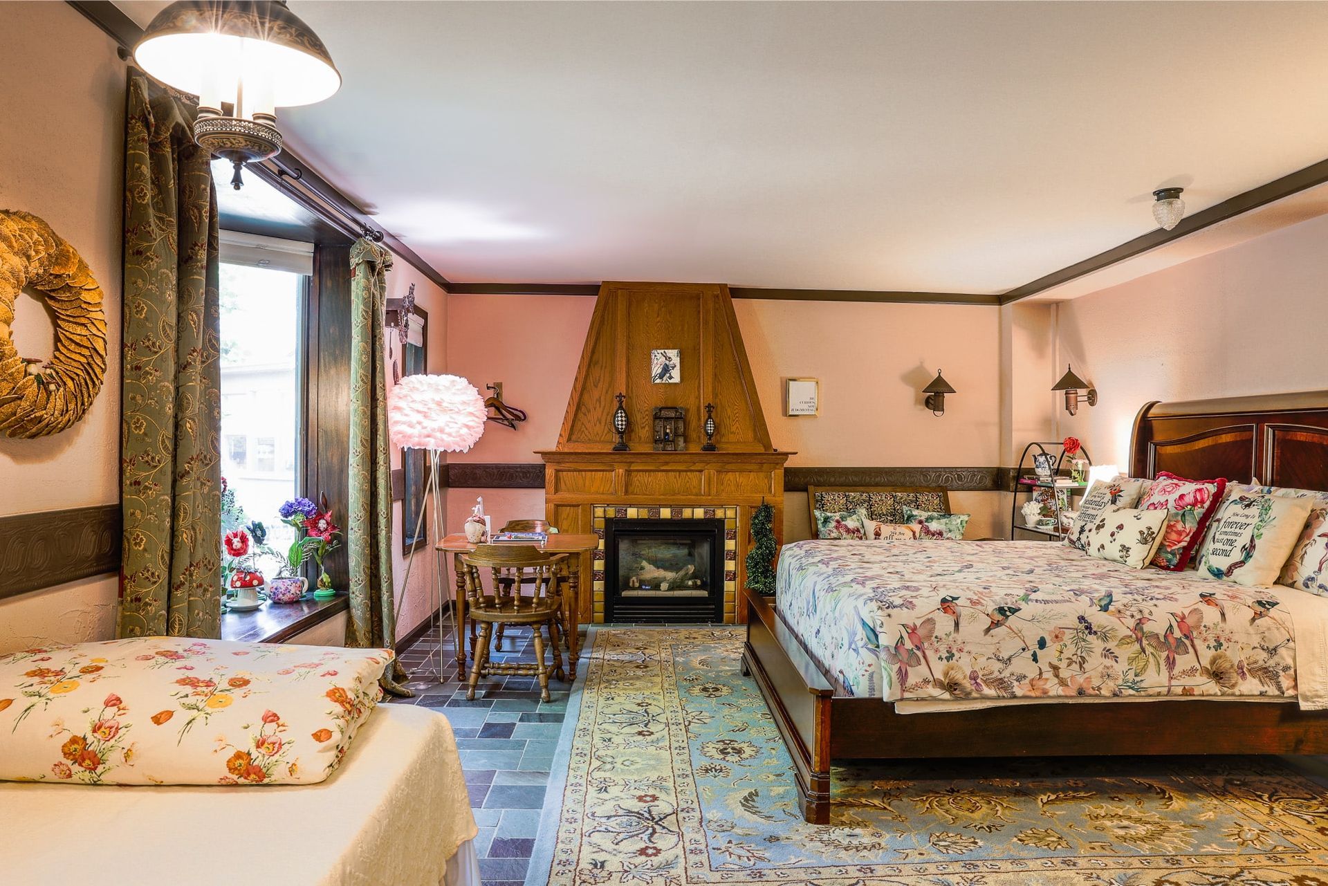 A bedroom with two beds , a fireplace and a table.