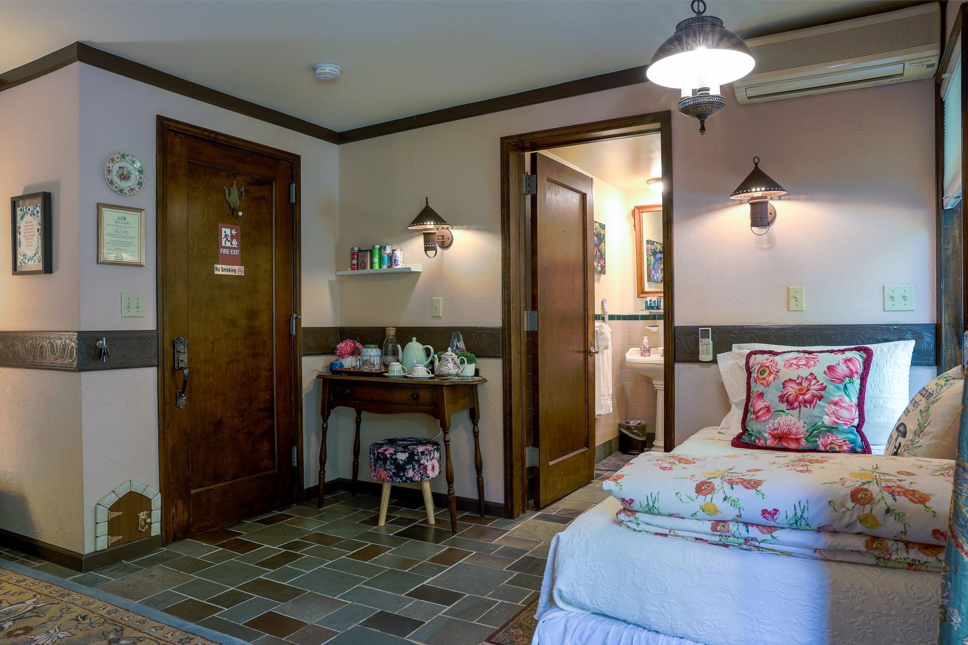 A bedroom with two beds , a desk , and a bathroom.