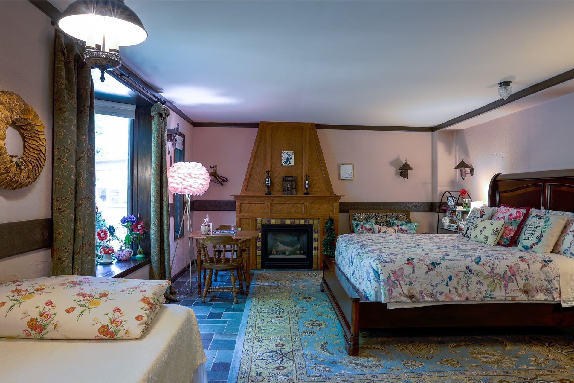 A bedroom with two beds , a fireplace and a table.