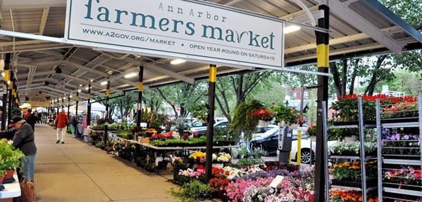A farmer 's market filled with lots of flowers and vegetables.
