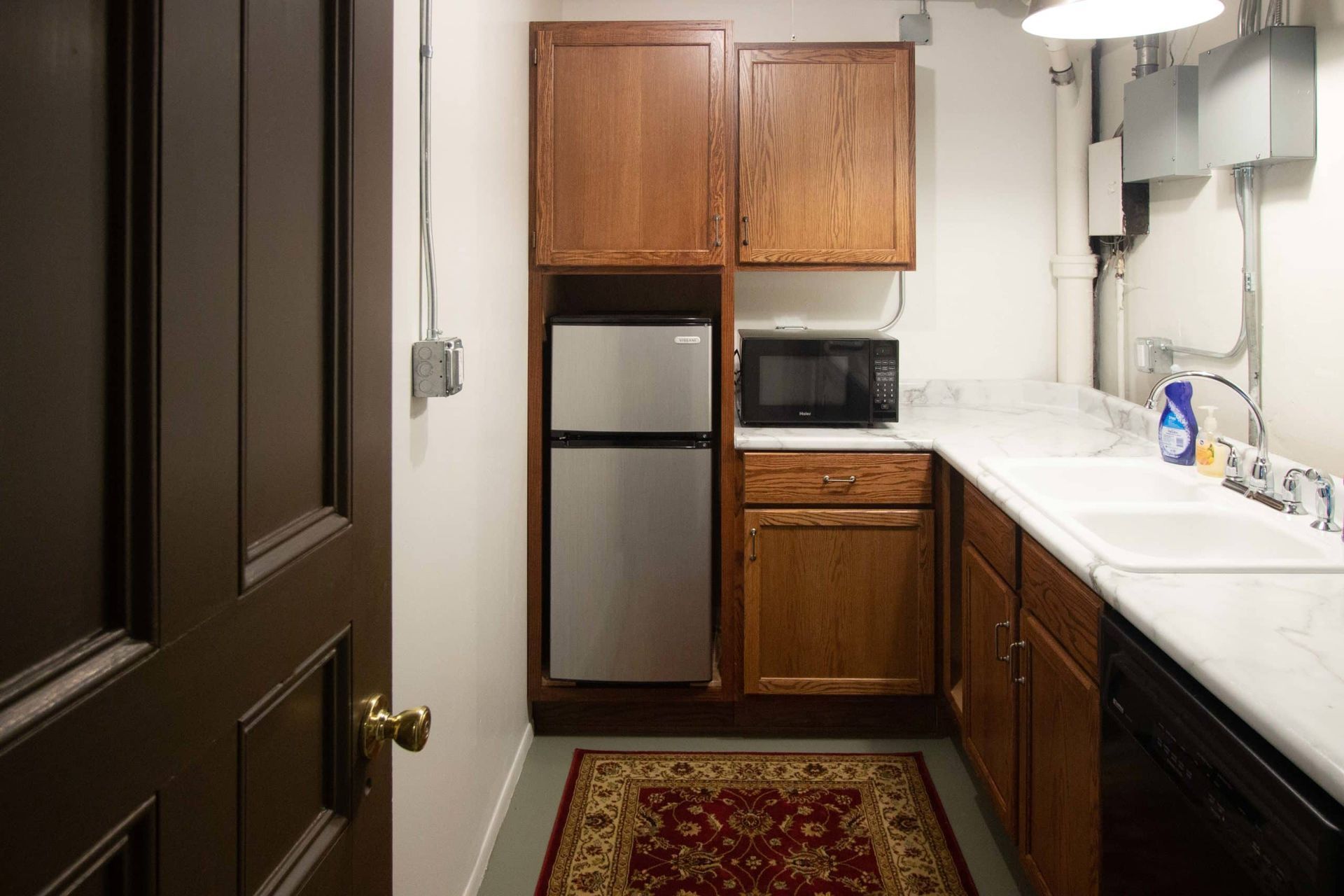 A kitchen with a refrigerator , microwave , sink and dishwasher.