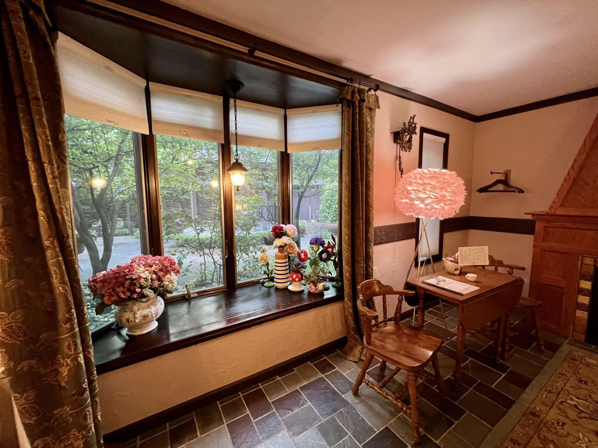 A room with a table and chairs in front of a large window.