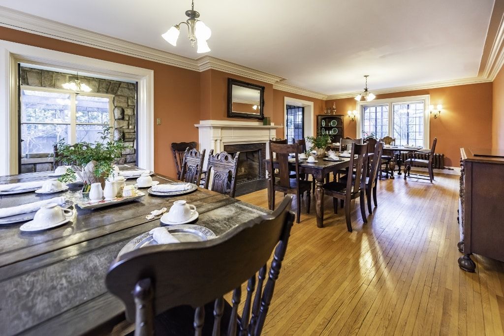 A large dining room with tables and chairs and a fireplace