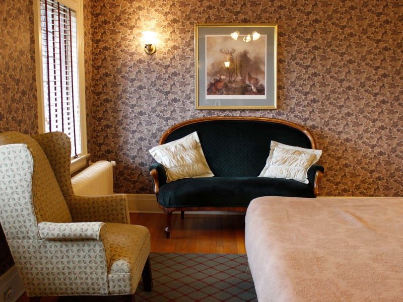 A living room with a couch a chair and a picture on the wall