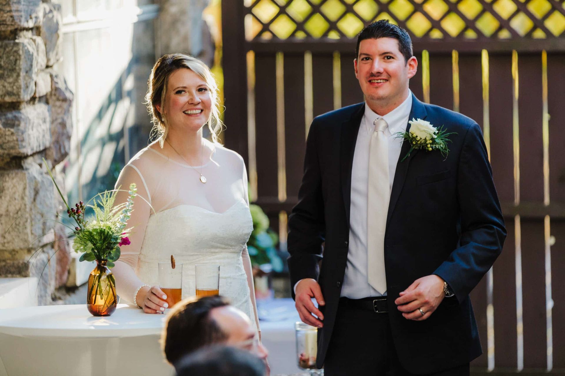 A bride and groom are standing next to each other at a wedding reception.