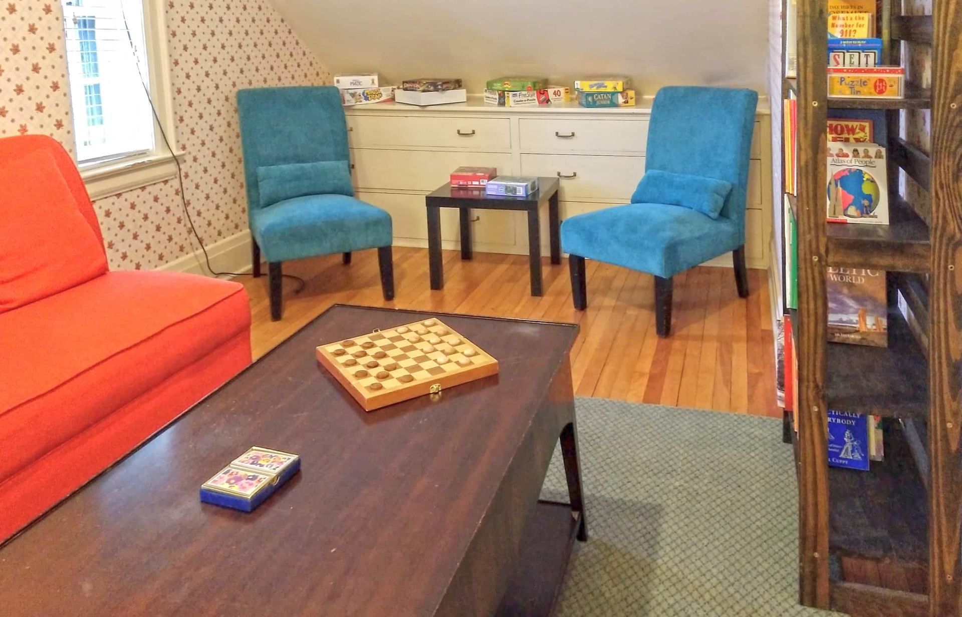A living room with a couch and chairs and a table with a board game on it