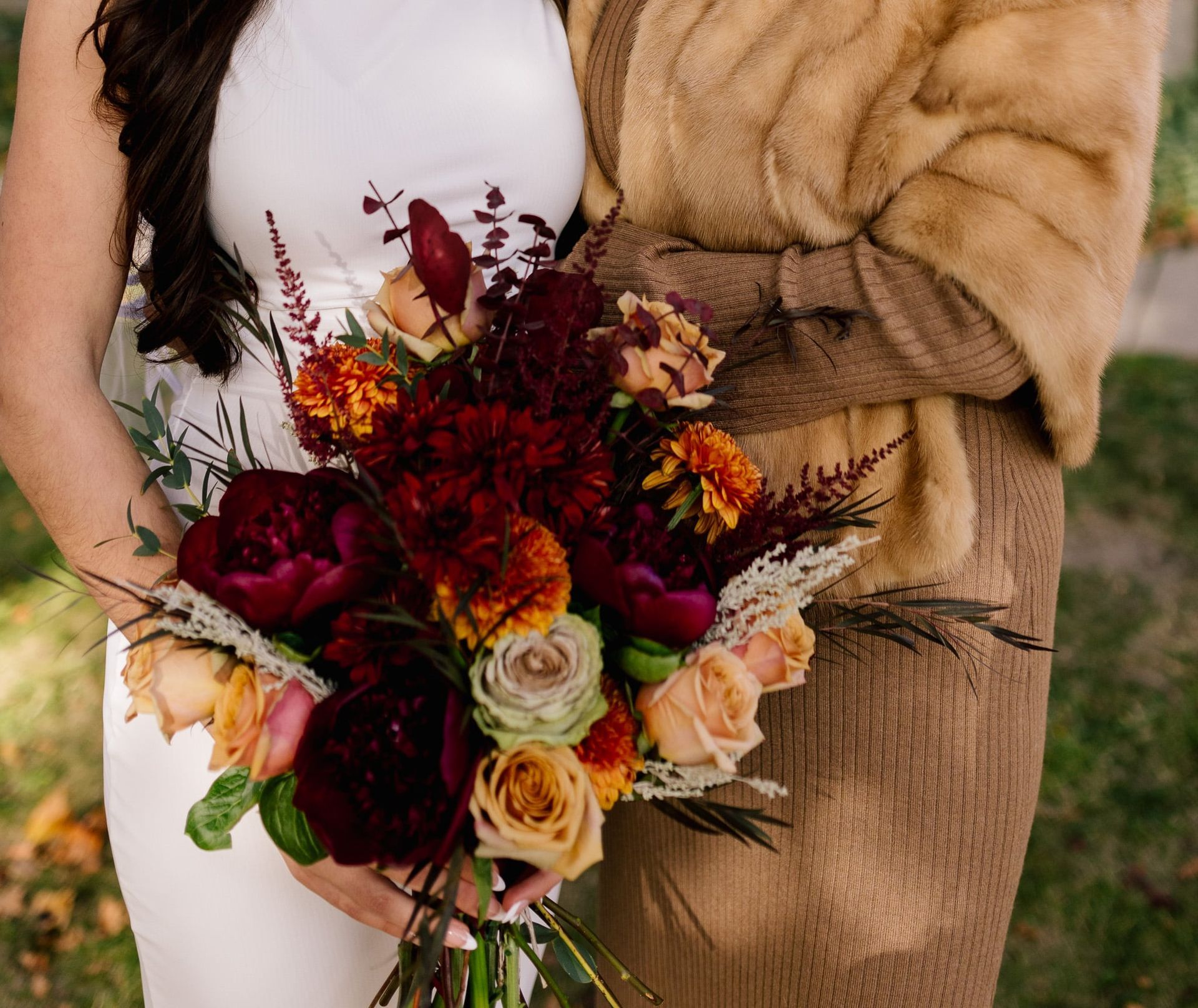 A woman in a white dress is holding a bouquet of flowers.