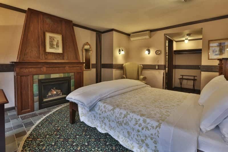 A bedroom with a fireplace and a bed