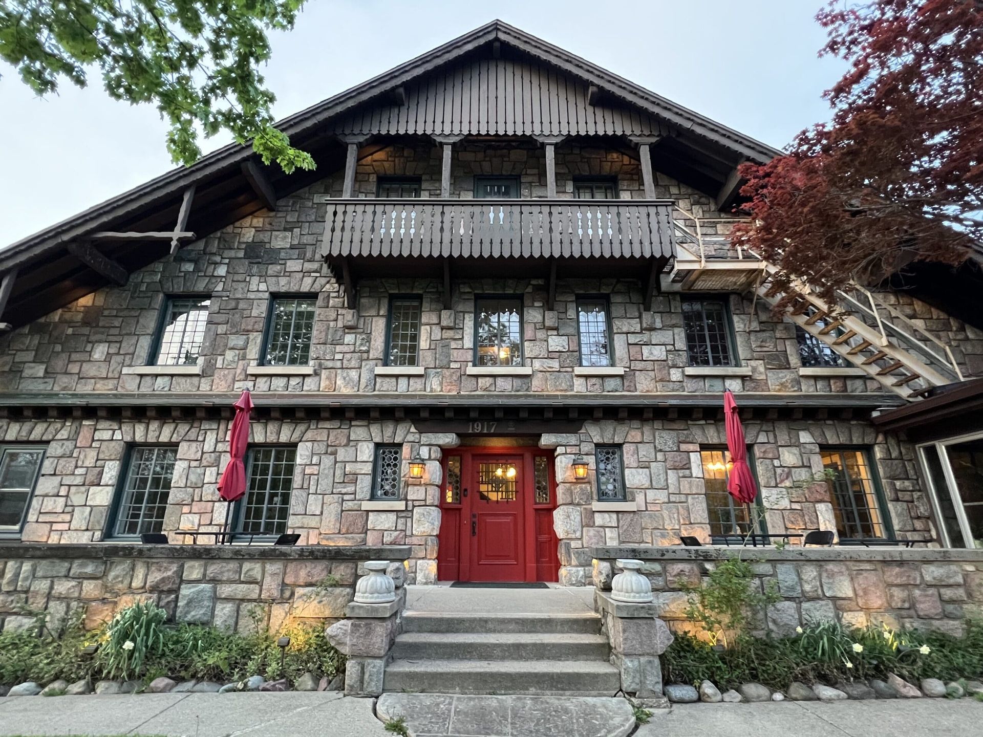 A large stone building with a red door and stairs