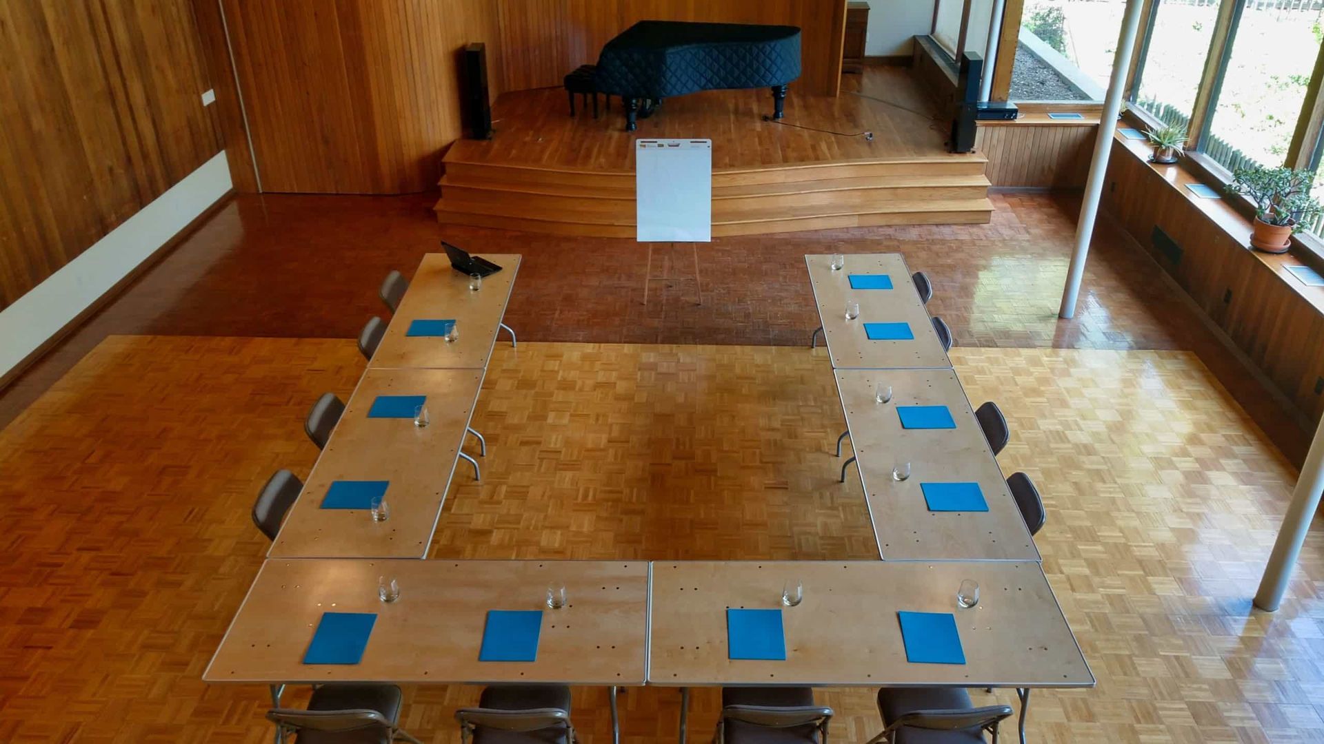 An aerial view of a conference room with tables and chairs and a piano.