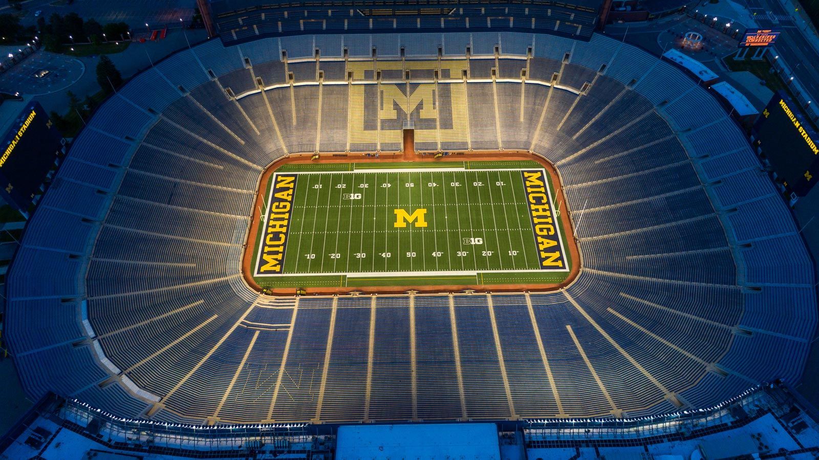 An aerial view of a football stadium with the letter m on the field