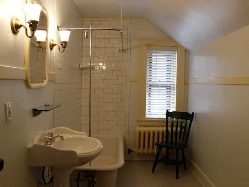 A bathroom with a sink a bathtub and a chair