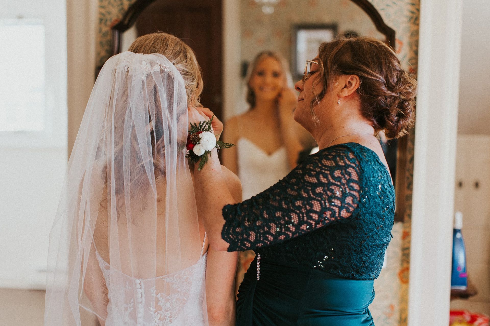 A mother of the bride is helping her daughter get ready for her wedding.
