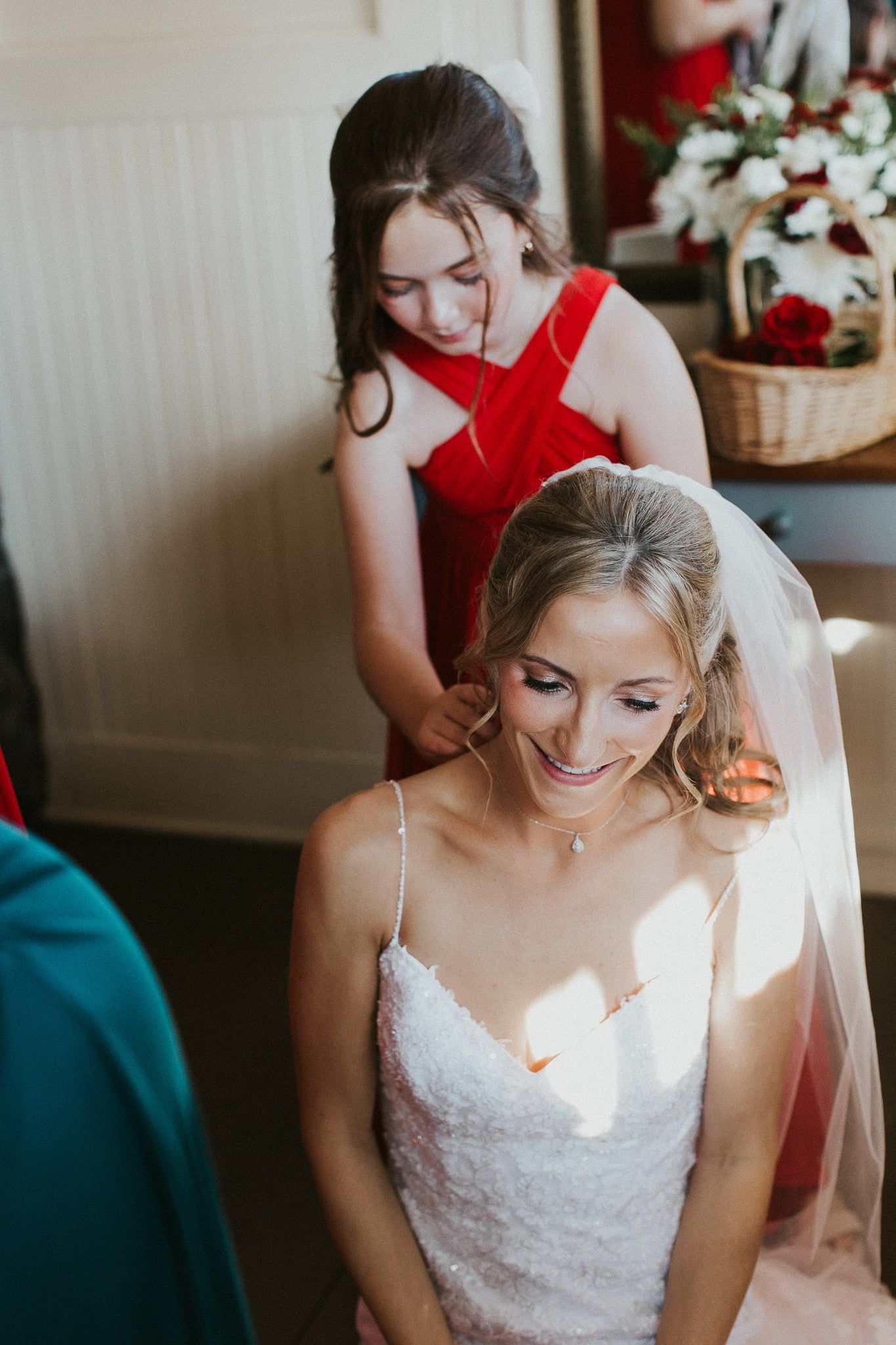A bride and her bridesmaid are getting ready for her wedding.