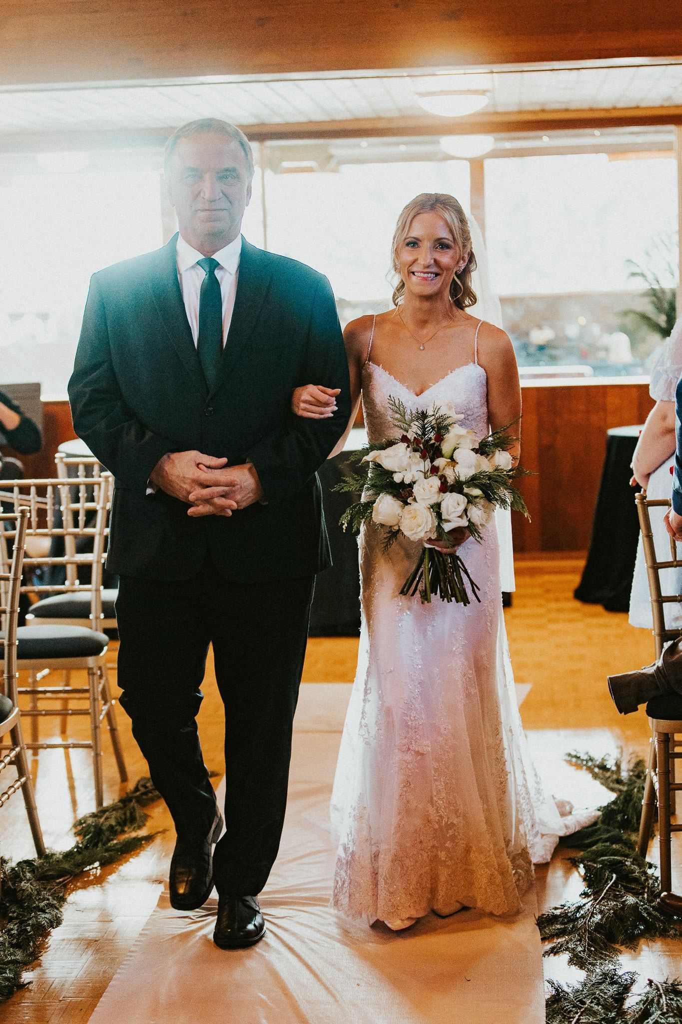 A long table with plates , utensils , and flowers on it.