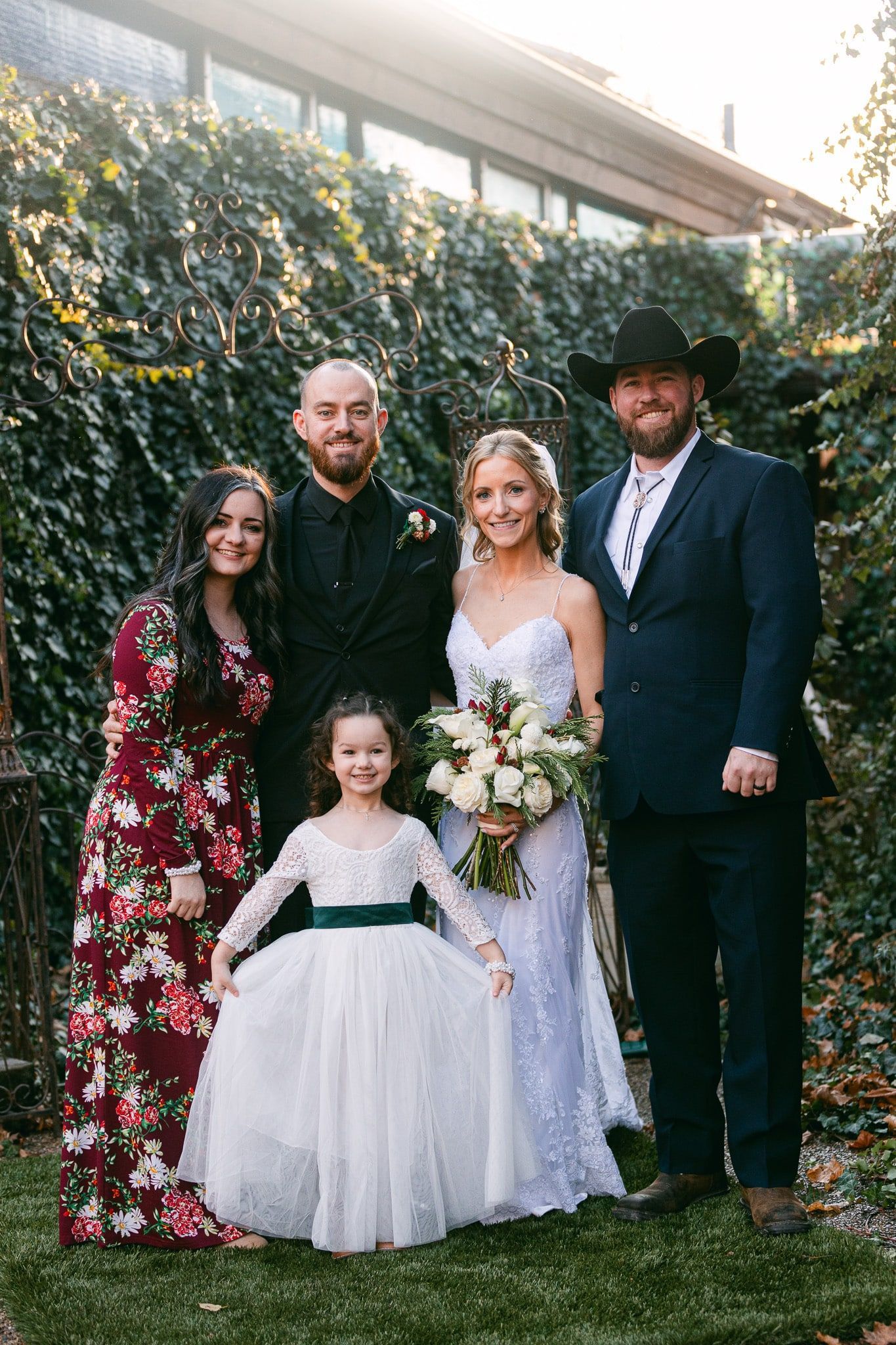 A bride and groom are posing for a picture with their family.
