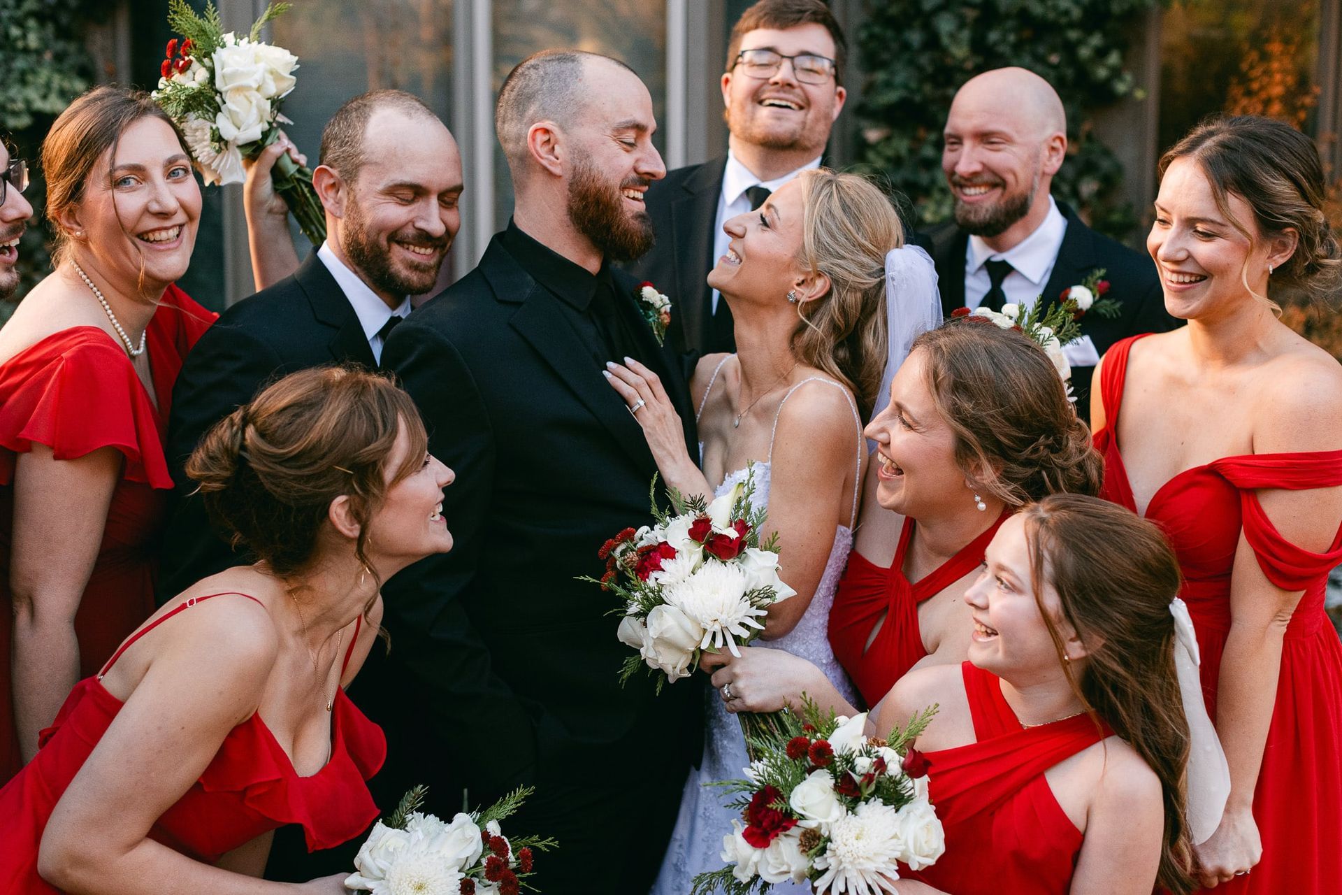A bride and groom are posing for a picture with their wedding party.