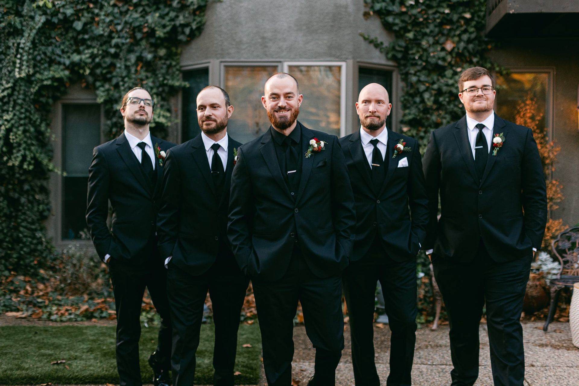 A group of men in suits and ties are standing next to each other in front of a building.