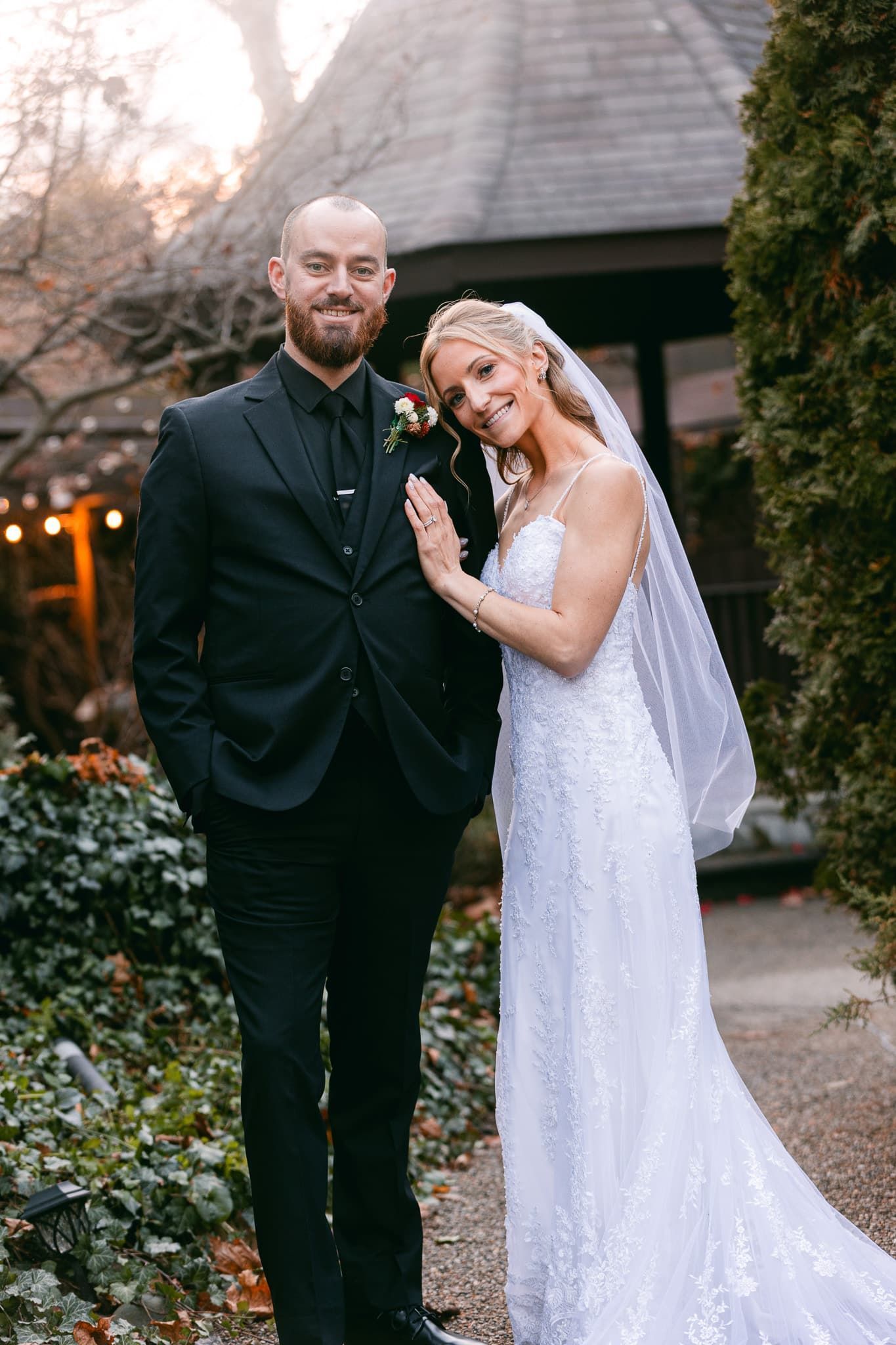 A bride and groom are posing for a picture in front of a building.