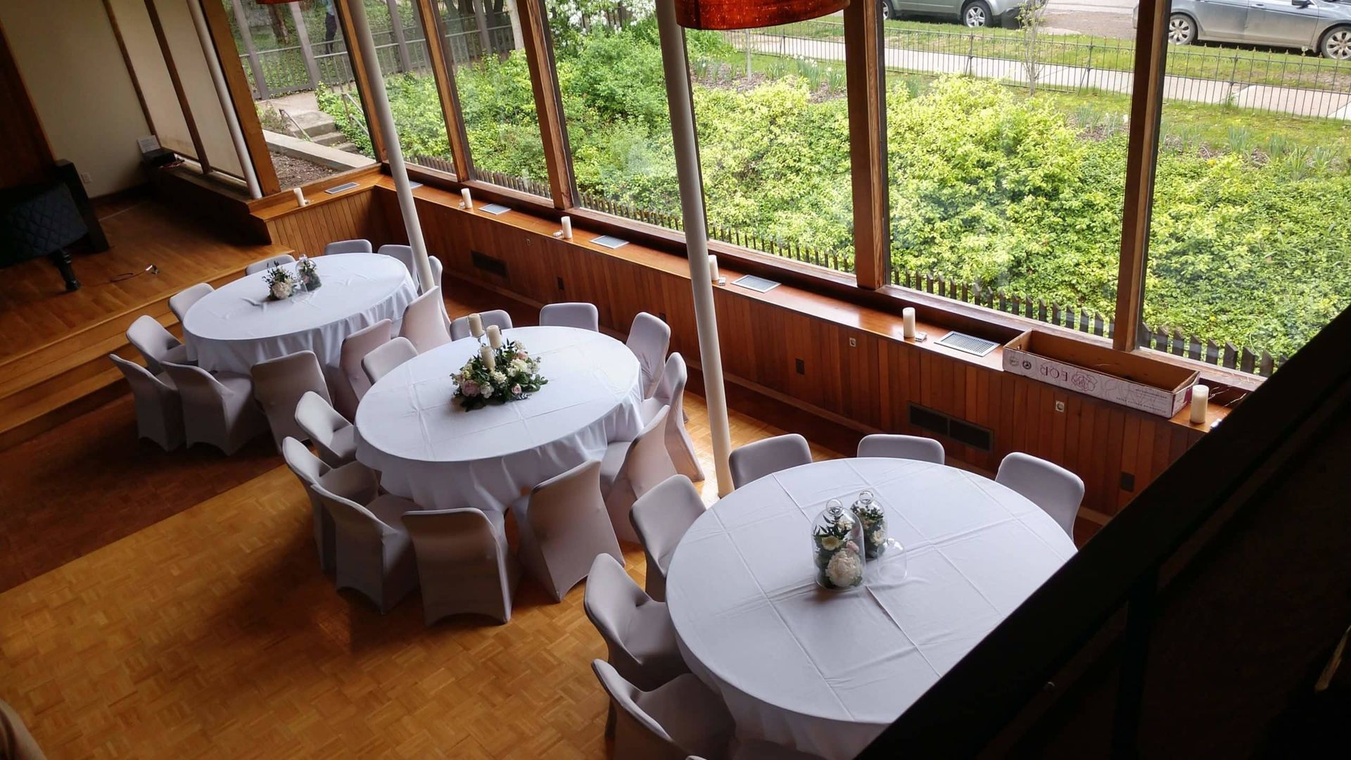 A room with tables and chairs set up for a wedding reception.